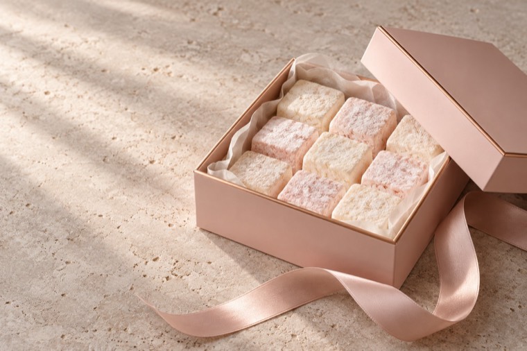 Concept: rose-pink gift box of marshmallows with satin ribbon