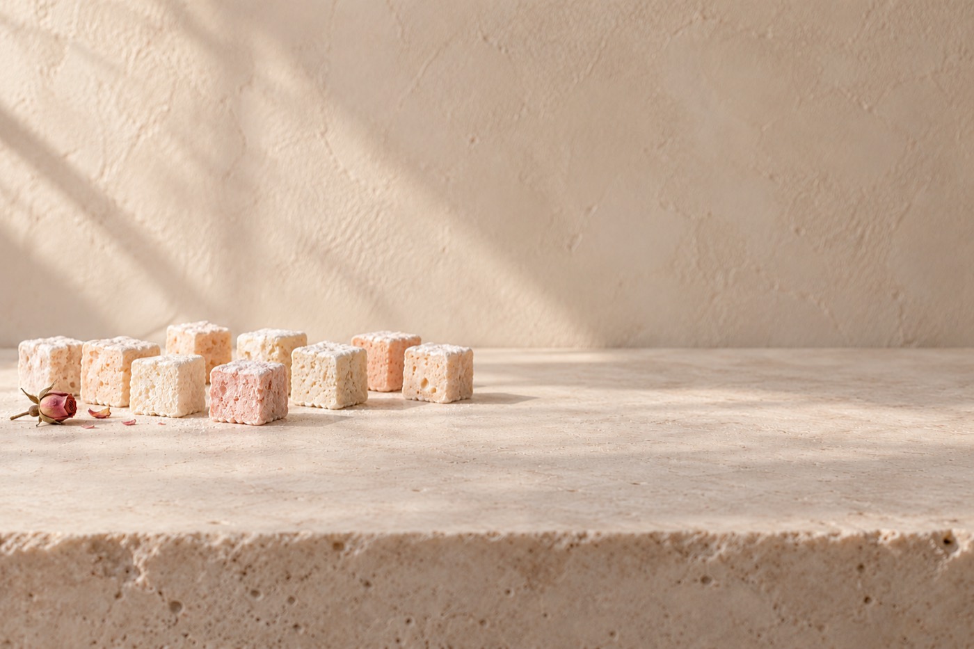 Honey marshmallow cubes on a limestone slab in window light